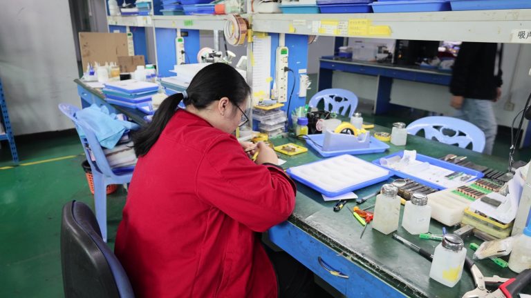 Technician working on an ultrasound probe at an ESD-protected repair bench